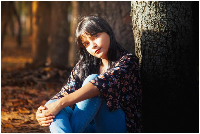 A serene portrait of a young woman sitting in a su