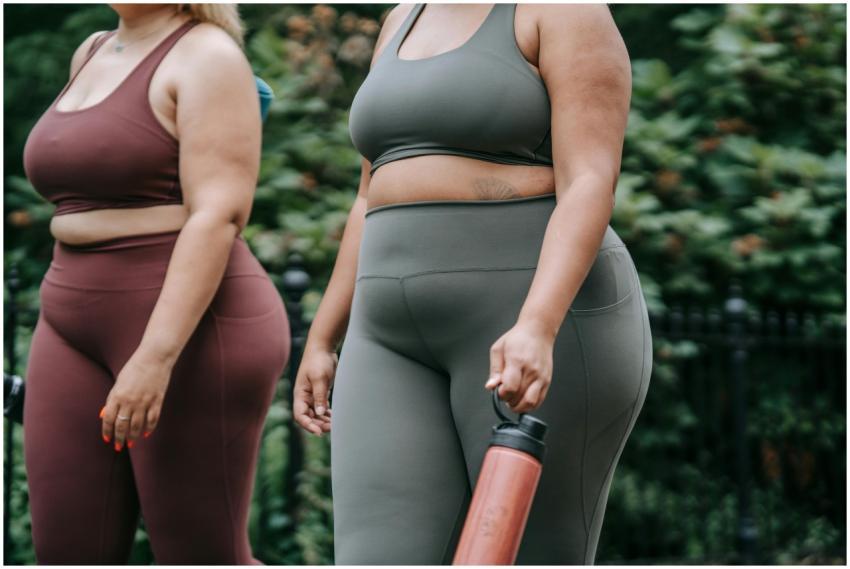 Two plus-size women exercising outdoors, showcasin