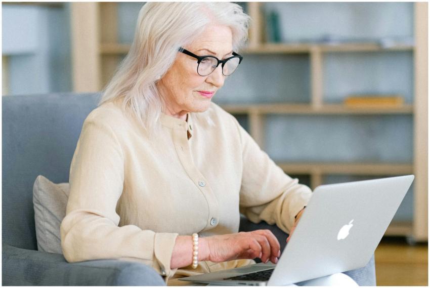 Senior woman sitting indoors using a laptop for on