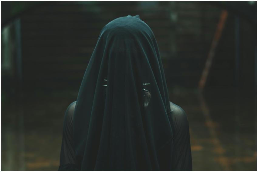 Intriguing image of a person draped in a dark veil