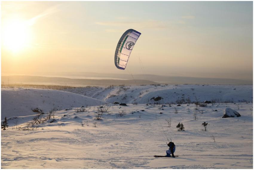 A kiteboarder enjoys a winter adventure on snowy h