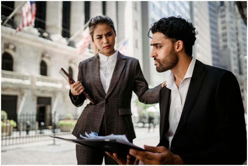 Two business professionals in formal attire discus