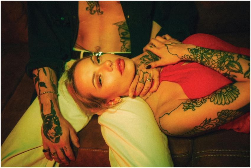 A romantic scene featuring a tattooed couple in an