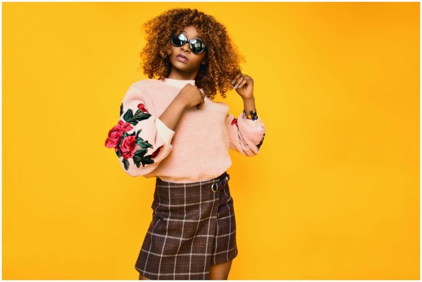 Chic woman with afro hair in a floral sweater and