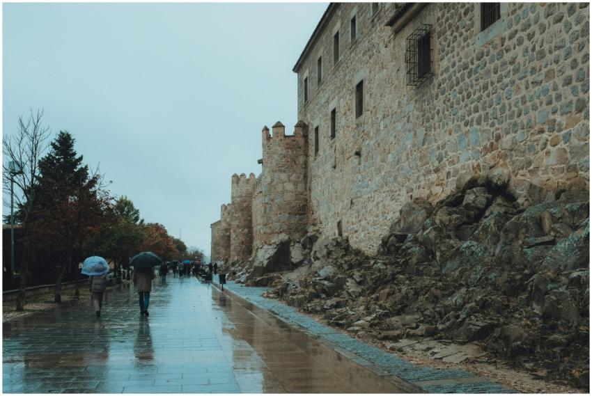 People walking along wet streets by the ancient wa