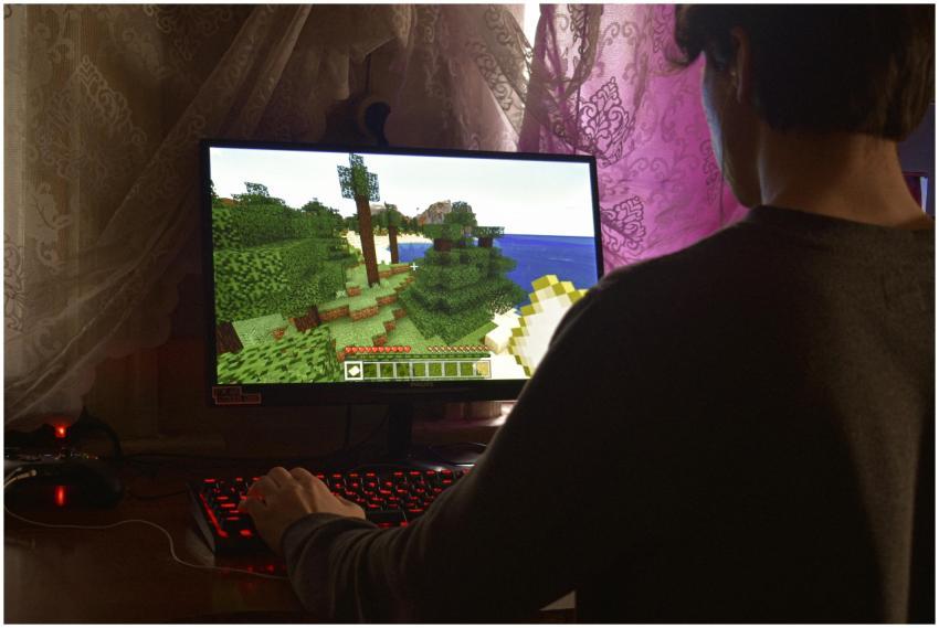 A young man intensely playing a PC video game indo