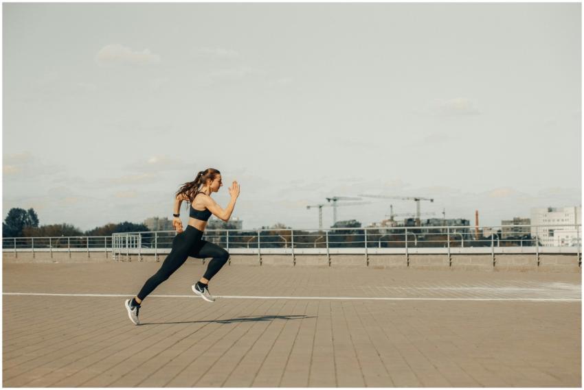 Woman sprinting on a rooftop in athletic wear duri