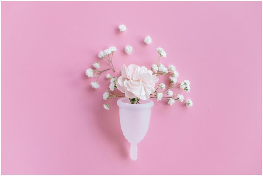 A menstrual cup filled with delicate flowers on a