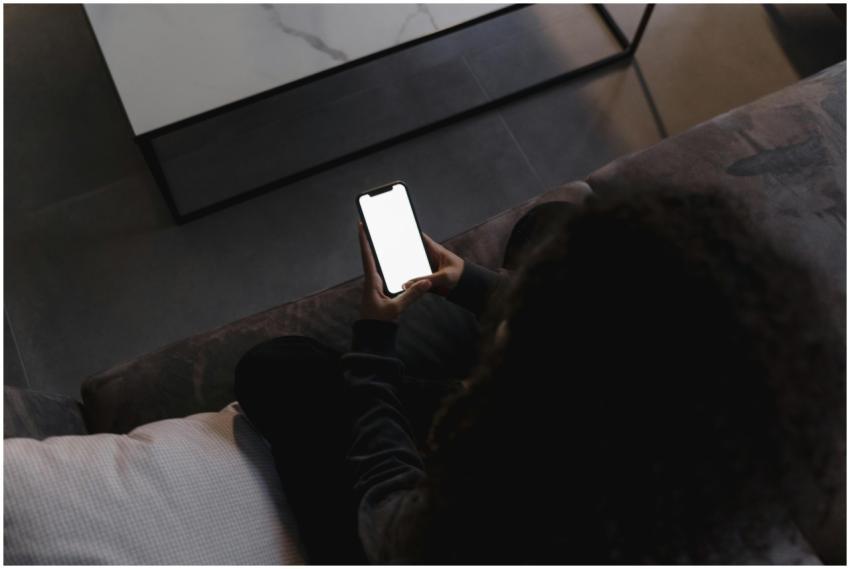 A person holding a smartphone with a blank screen,