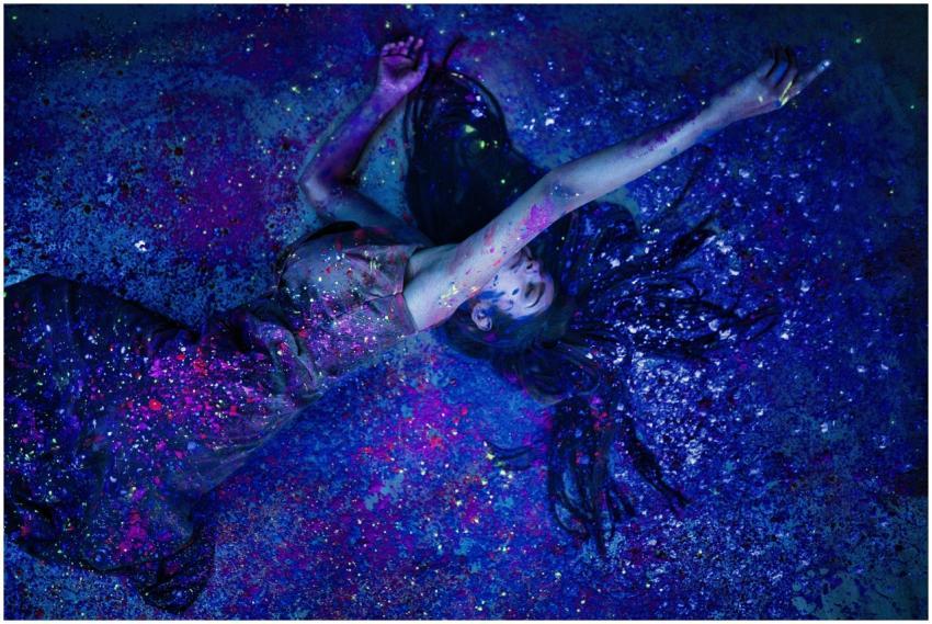 Artistic shot of a glamorous woman in a dress surr