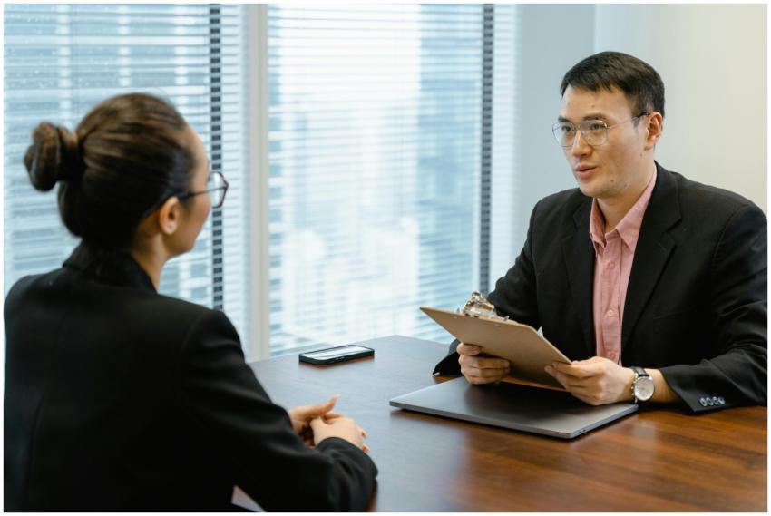 Two professionals discussing at an office table, i