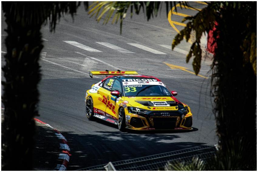 A vibrant yellow race car speeding around the Pau
