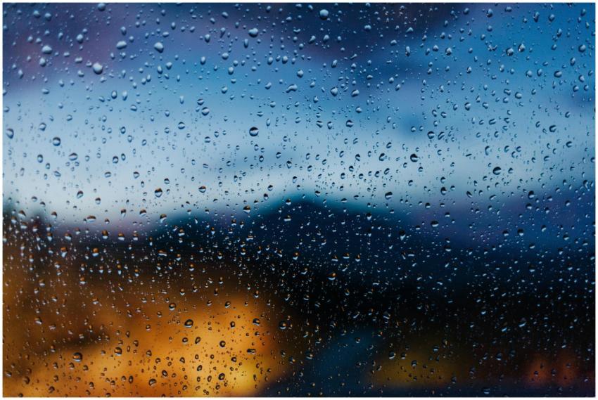 Raindrops on a window with blurred evening lights,