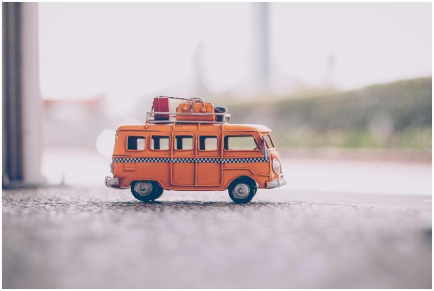 Close-up of a vintage orange toy van with luggage