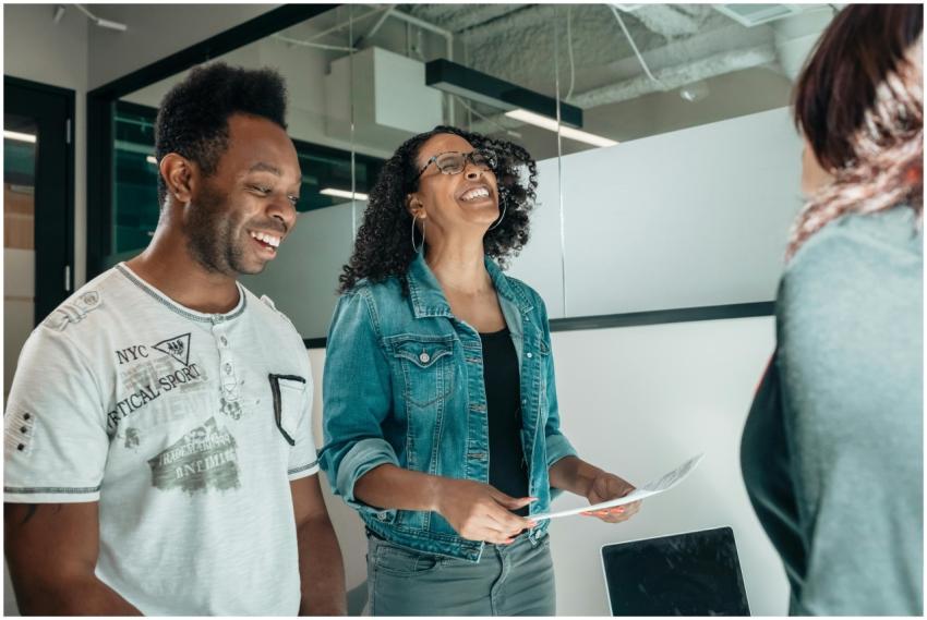 Smiling couple discussing with an advisor in a mod