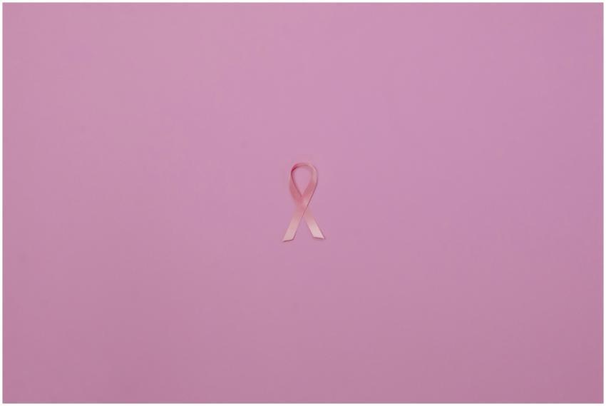 Pink ribbon on pastel background symbolizing breas