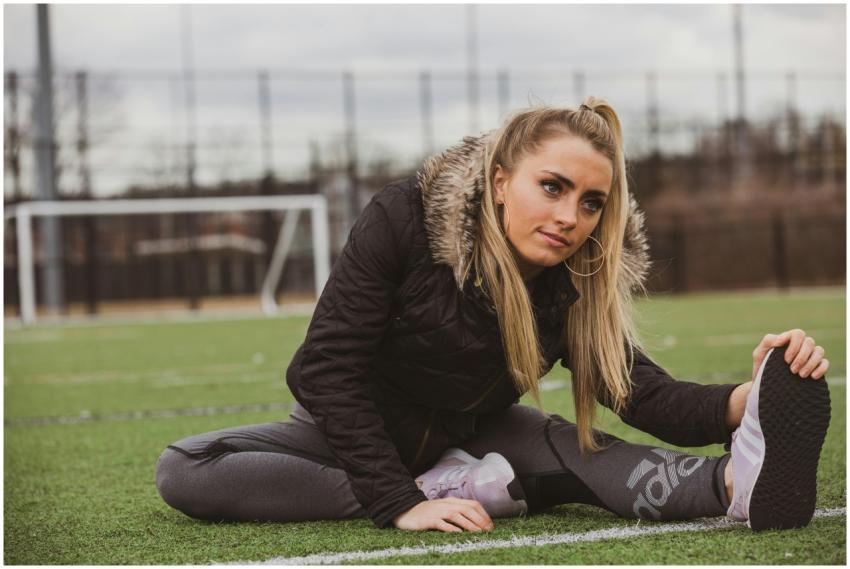 A young woman stretching on a soccer field in Oyst