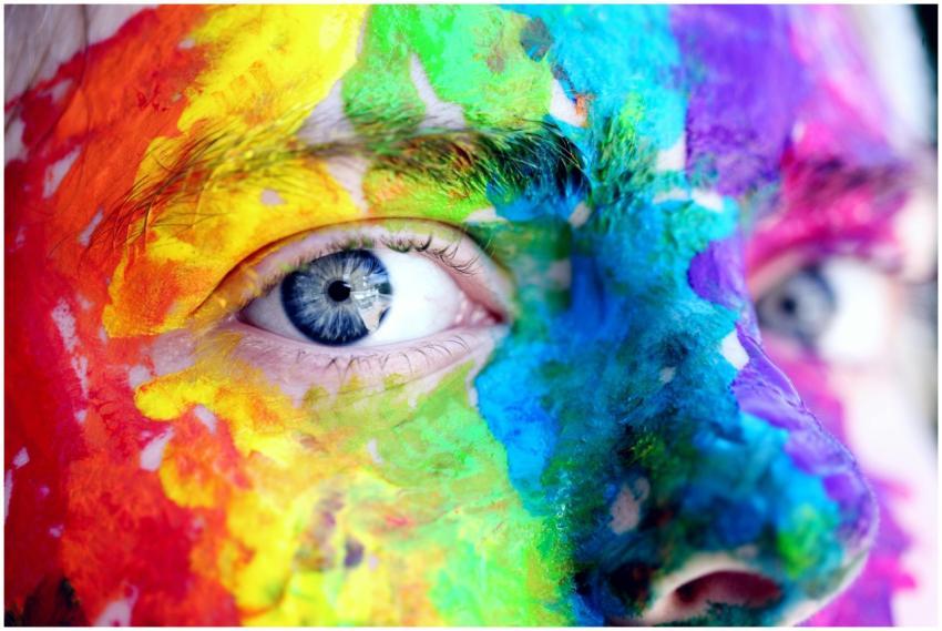 Close-up of a person with colorful rainbow face pa