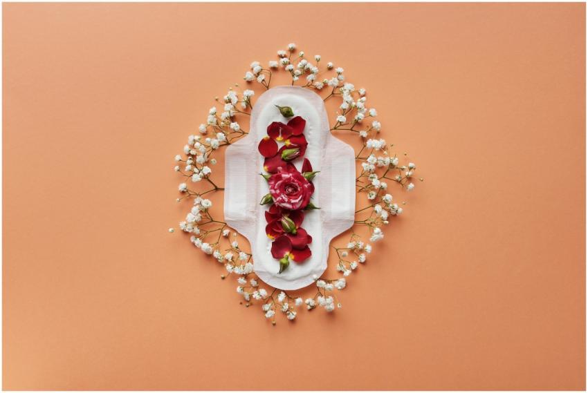 Artistic flatlay of a sanitary pad adorned with fl