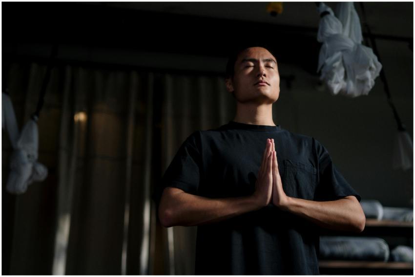 An adult male practicing meditation in a yoga stud