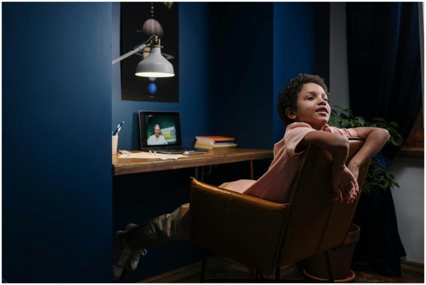A young student relaxes while learning online in a