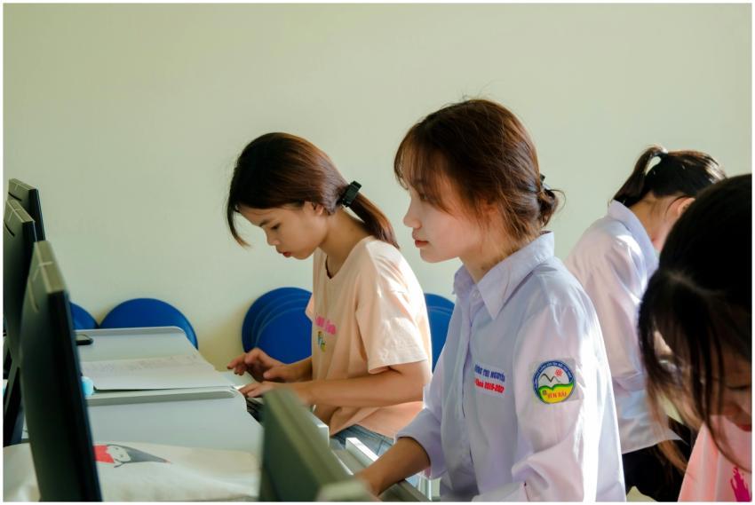 Three young women concentrating on a computer task