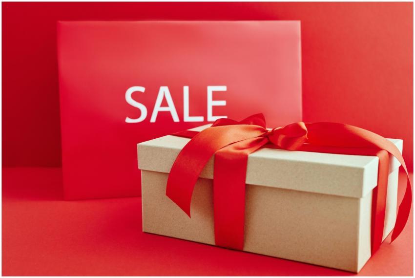 Gift box with red ribbon on red background with sa