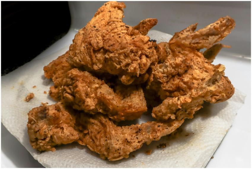 Golden brown fried chicken wings on a paper towel,