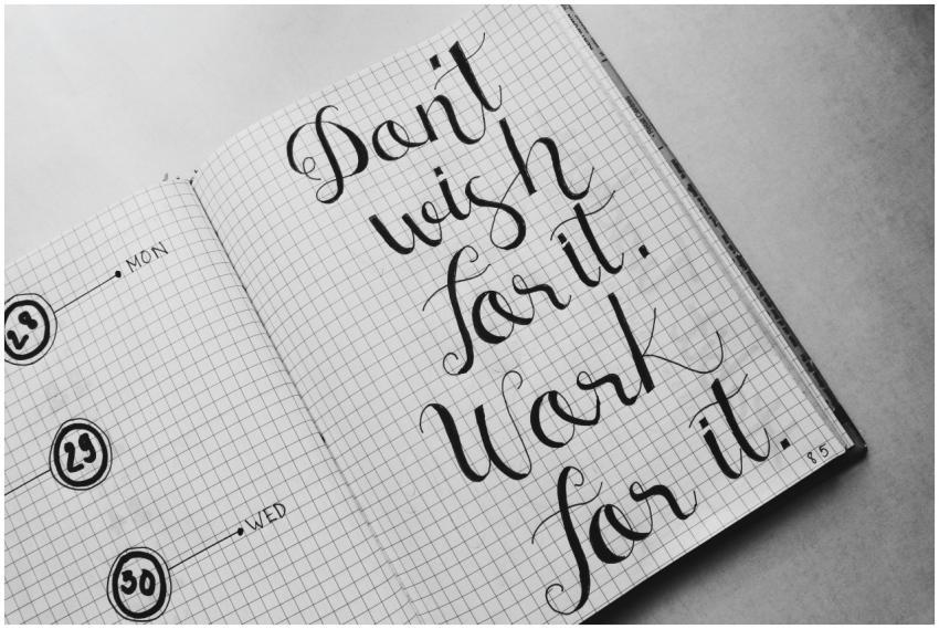 Close-up of motivational calligraphy on grid paper