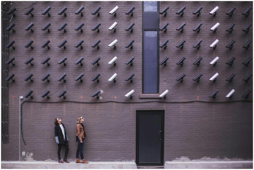 Women observing a wall covered with numerous secur