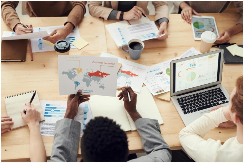 Diverse professionals brainstorming with laptops a