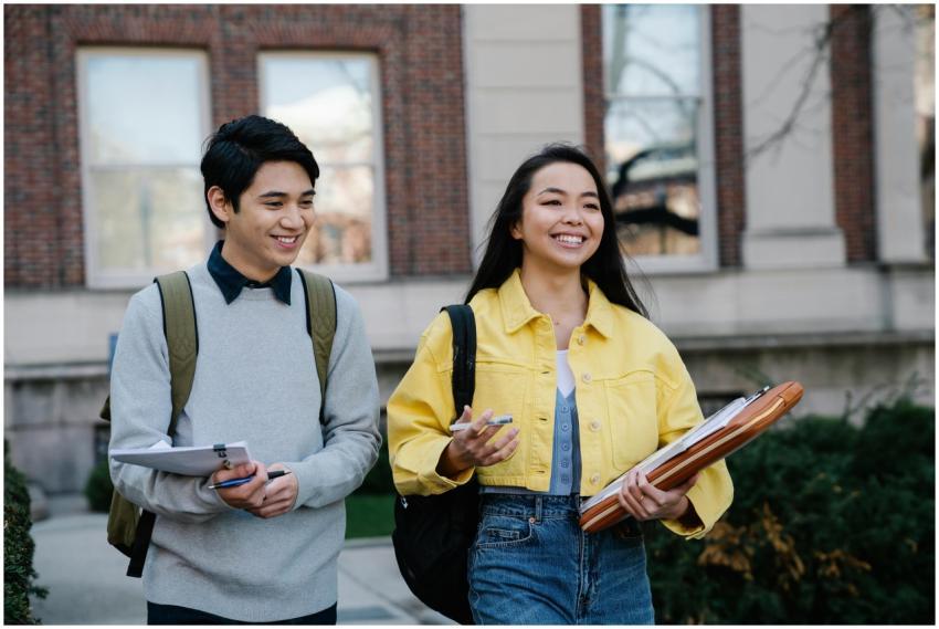 Two smiling students walking outdoors on a college