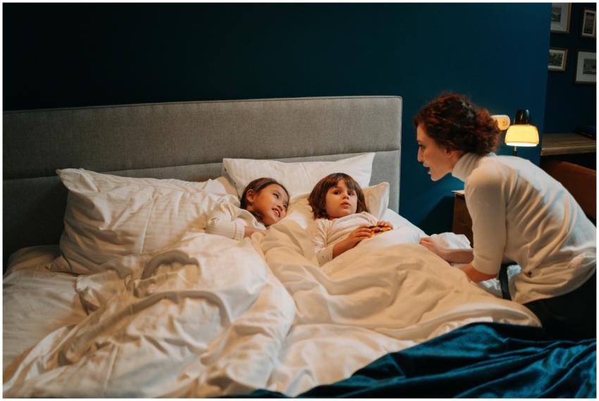 A nanny telling a bedtime story to two children in