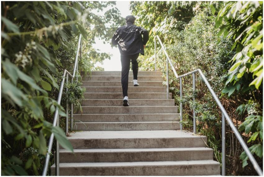 A man in sports clothing running up steps outdoors