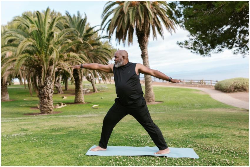 A senior man practicing yoga on a mat in a sunny p