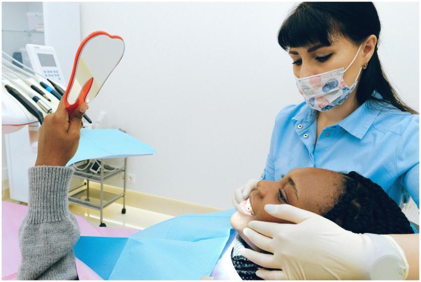 Dentist assisting a happy patient checking her smi