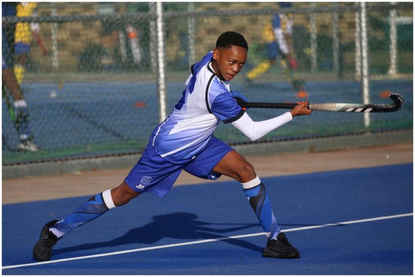 Young male athlete performing a powerful field hoc