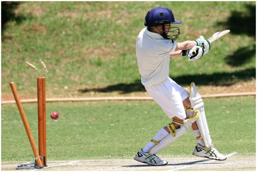 Young cricket player in full gear performing a swe