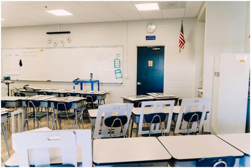 Bright empty classroom featuring desks, a whiteboa