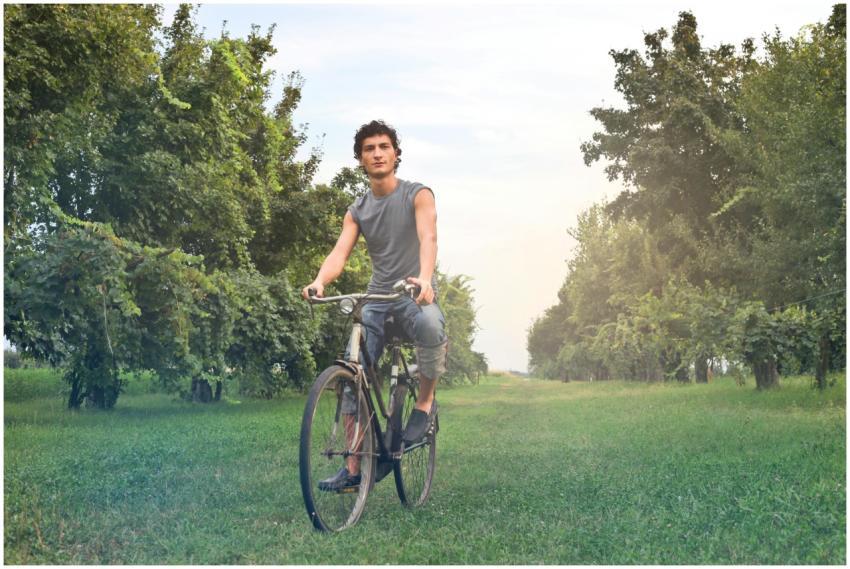 A young man enjoys a bike ride through beautiful g
