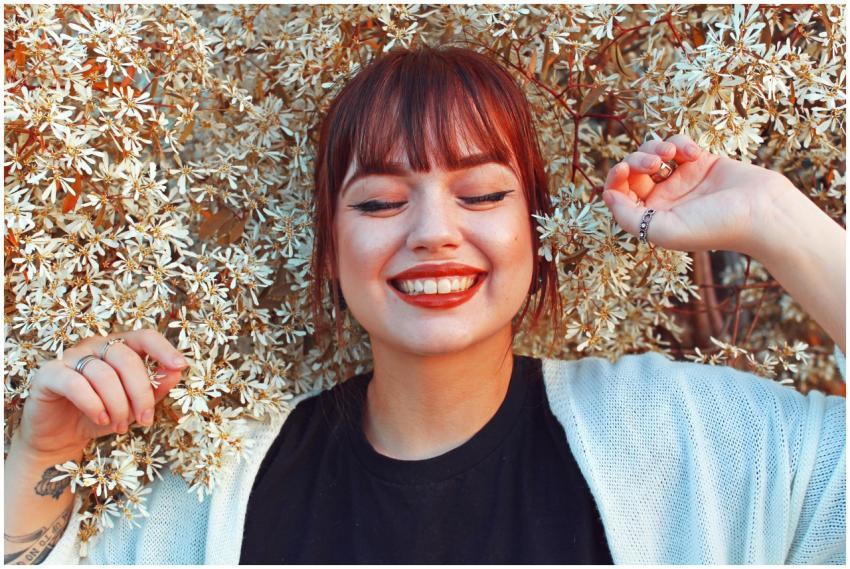 Redhead woman smiling with closed eyes, surrounded