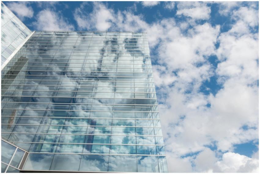 A contemporary skyscraper with glass panels reflec