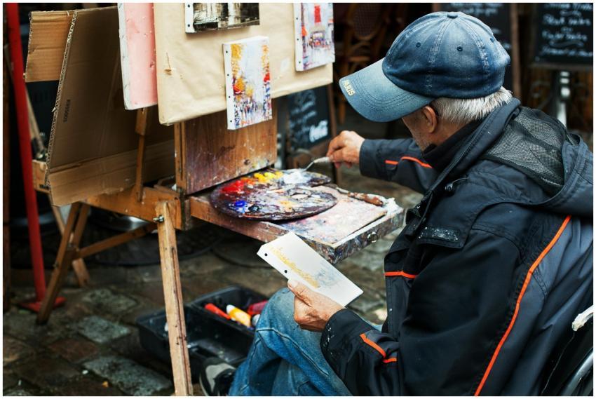 A street artist paints colorful abstracts on canva