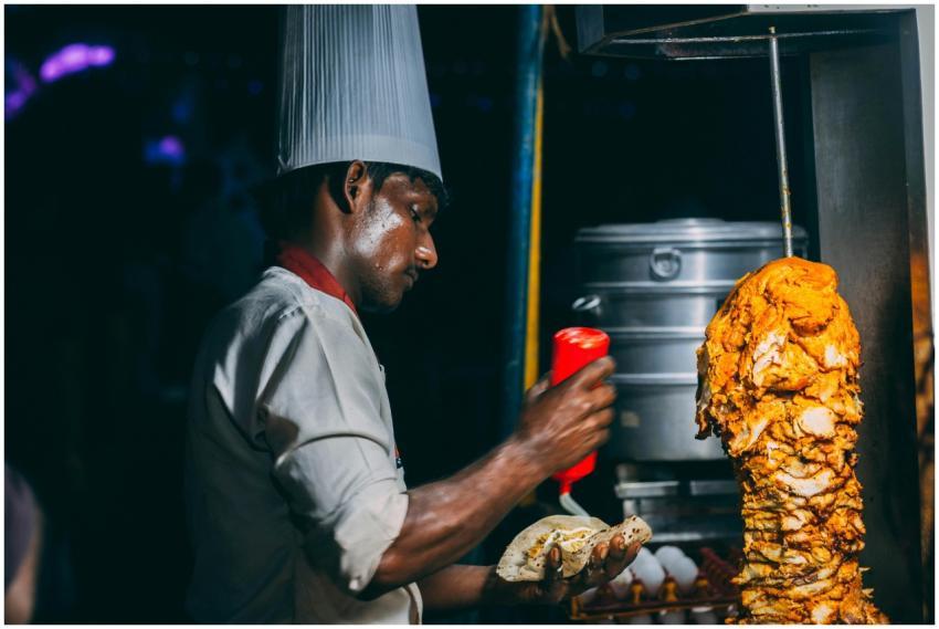 A chef skillfully prepares shawarma in a night mar
