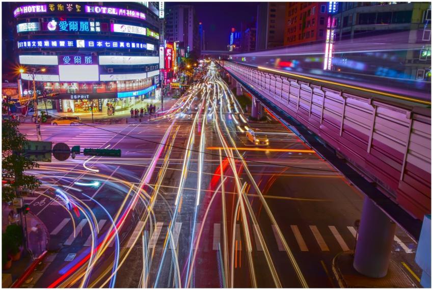 Dynamic city intersection with colorful light trai