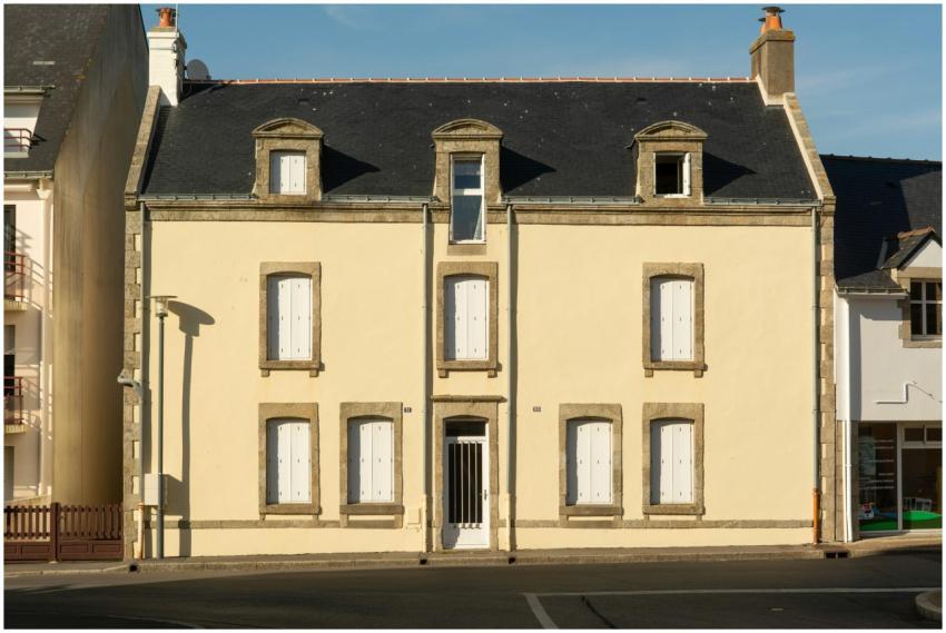 Historic townhouse facade in La Turballe, reflecti