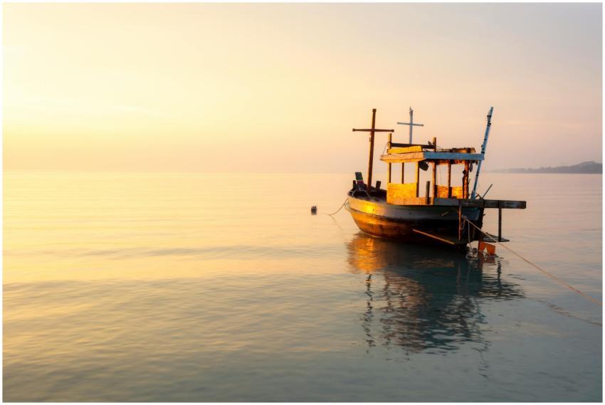 A peaceful scene of a moored wooden boat at sunset