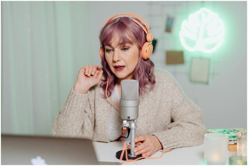 Woman podcaster in a cozy room speaking into a mic