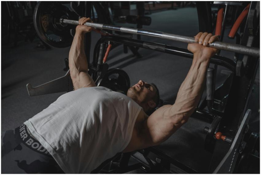 A focused man lifts heavy weights on a bench press