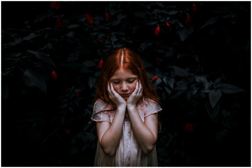 A young redhead girl in a thoughtful pose surround
